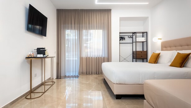 Una habitación de hotel moderna con cama, mesita de noche y armario.