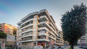 Un edificio de varios pisos con balcones y una entrada al nivel de la calle.