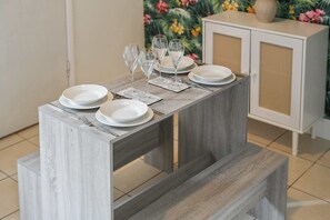 Een eettafel gedekt met borden, glazen en bestek, met een kast op de achtergrond.
