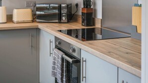 A modern kitchen with a built-in microwave, toaster, and oven.