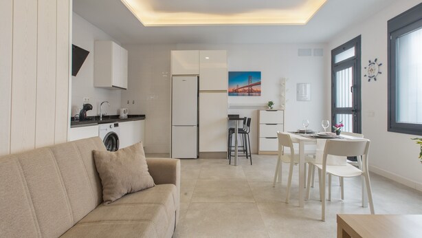 Un appartement moderne comprenant un salon, une cuisine, un coin repas et une grande fenêtre.