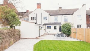 A residential property with a paved patio, a small lawn, and a wooden fence. - Modern Town Centre House w/ En-Suites & Fast WiFi (Tamworth)