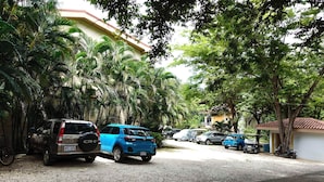 Una calle residencial con coches aparcados y árboles.