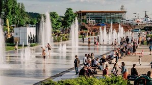A public square with multiple water fountains, a modern building, and people walking and sitting. - Lévis Center | New Studio with Queen Bed + A/C (Levis)