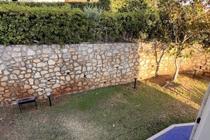 A stone wall with a small bench and a metal lamp post in a garden area. - Villa with garden just minutes from the sea (Sparvasile)