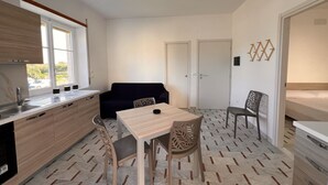 Una cocina compacta con comedor, un sofá y una silla.