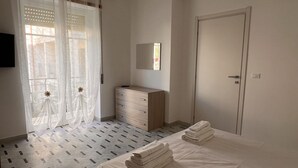 Un dormitorio con cama, cómoda, espejo y puerta.