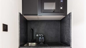 A compact kitchen with a microwave, sink, and a small coffee machine. - Spacious Studio - 2P - Beaugrenelle/eiffel Tower (Paris)