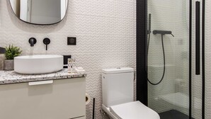 A modern bathroom with a white sink, a toilet, and a glass-enclosed shower. - Spacious Studio - 2P - Beaugrenelle/eiffel Tower (Paris)