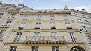A multi-story building with classical architecture, featuring ornate balconies and large windows. - Charming Apartment - 2br/6p - Gare Saint-lazare (Paris)