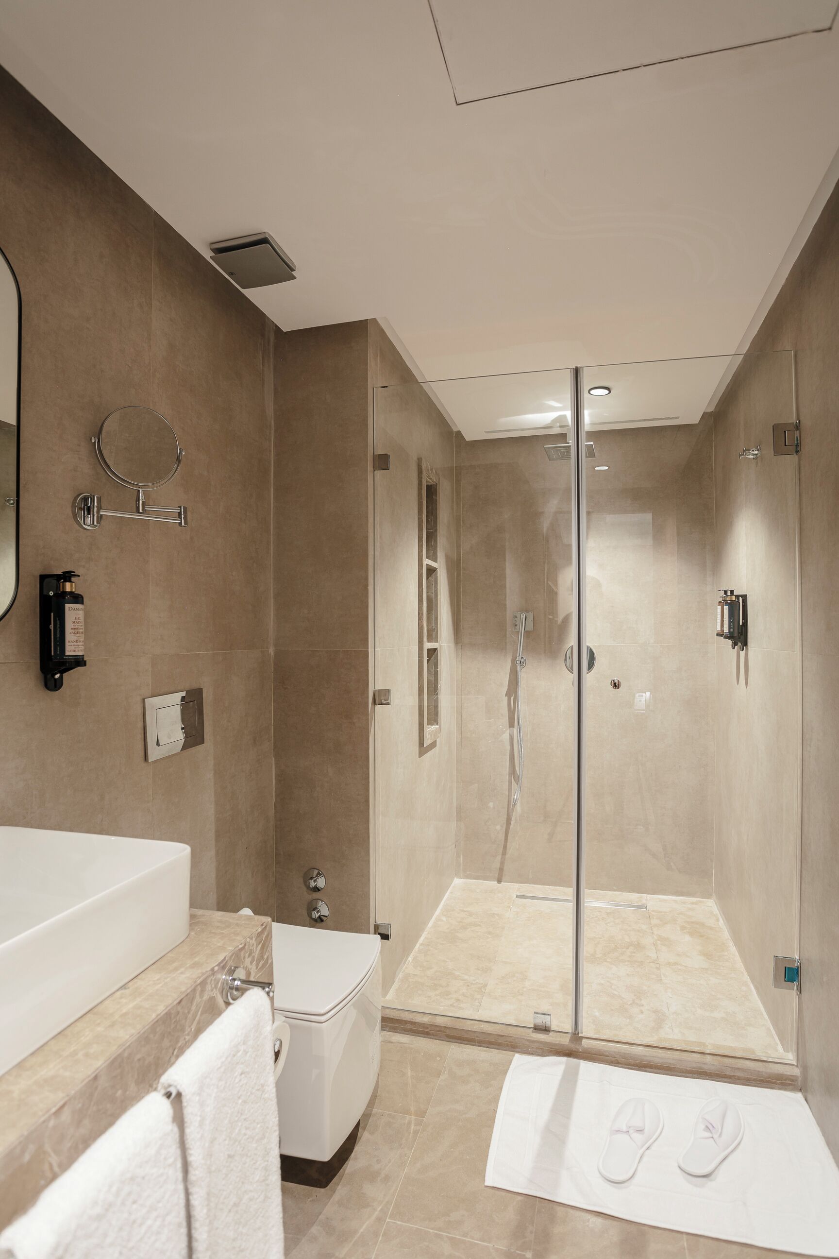 Un baño moderno con bañera, inodoro y zona de ducha con mampara de vidrio.