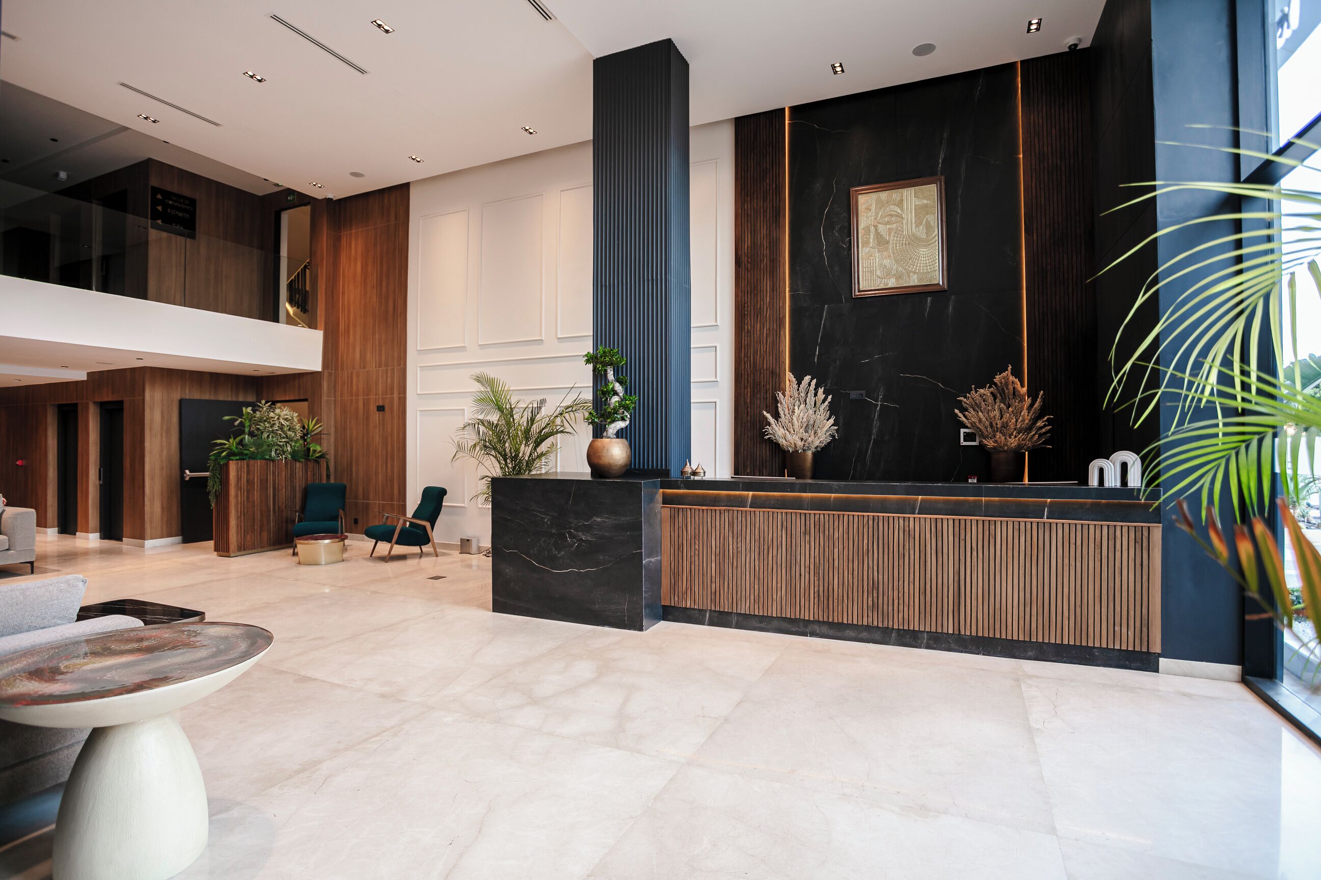 A modern reception area with a black reception desk, wooden paneling, and a large window.