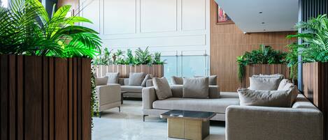 A modern living room with a sofa set, a coffee table, and potted plants.