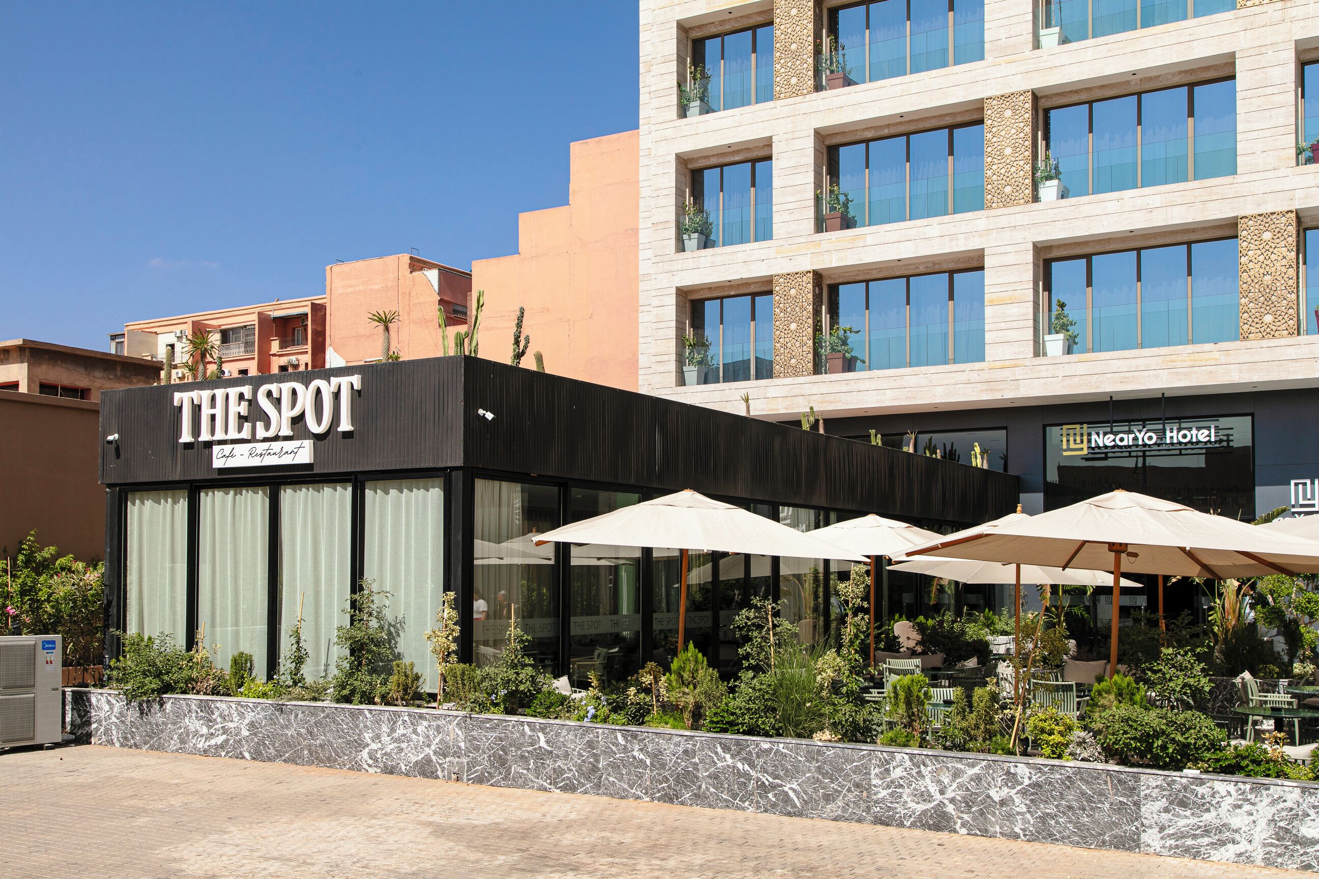 Un edificio moderno con un cartello che riporta la scritta "THE SPOT Cafe - Restaurant".