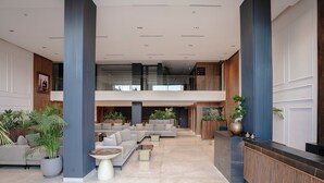 A spacious lobby with a reception desk, seating area, and large windows. - NearYo Hotels (Marrakech)