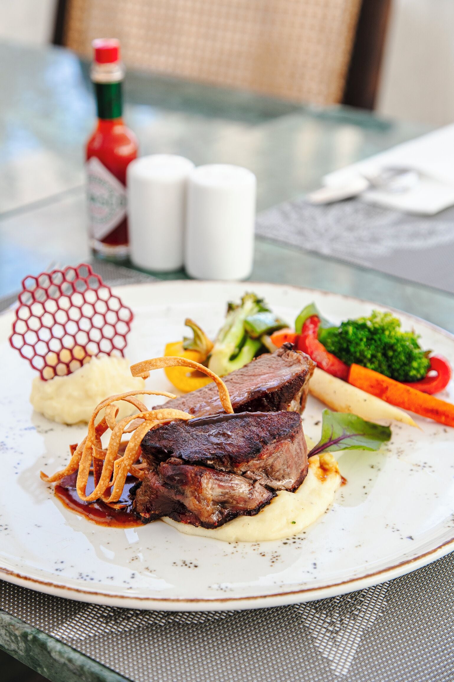 A plate of food with steak, vegetables, and mashed potatoes.