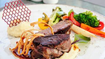 A plate of food with steak, vegetables, and mashed potatoes.