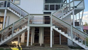 Een gebouw met twee verdiepingen, een centraal trappenhuis en een aangrenzend balkon.