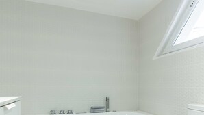 Un baño moderno con bañera, inodoro y tragaluz.