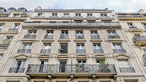 Un edificio de varios pisos con un estilo arquitectónico clásico, que presenta balcones ornamentados y grandes ventanales.