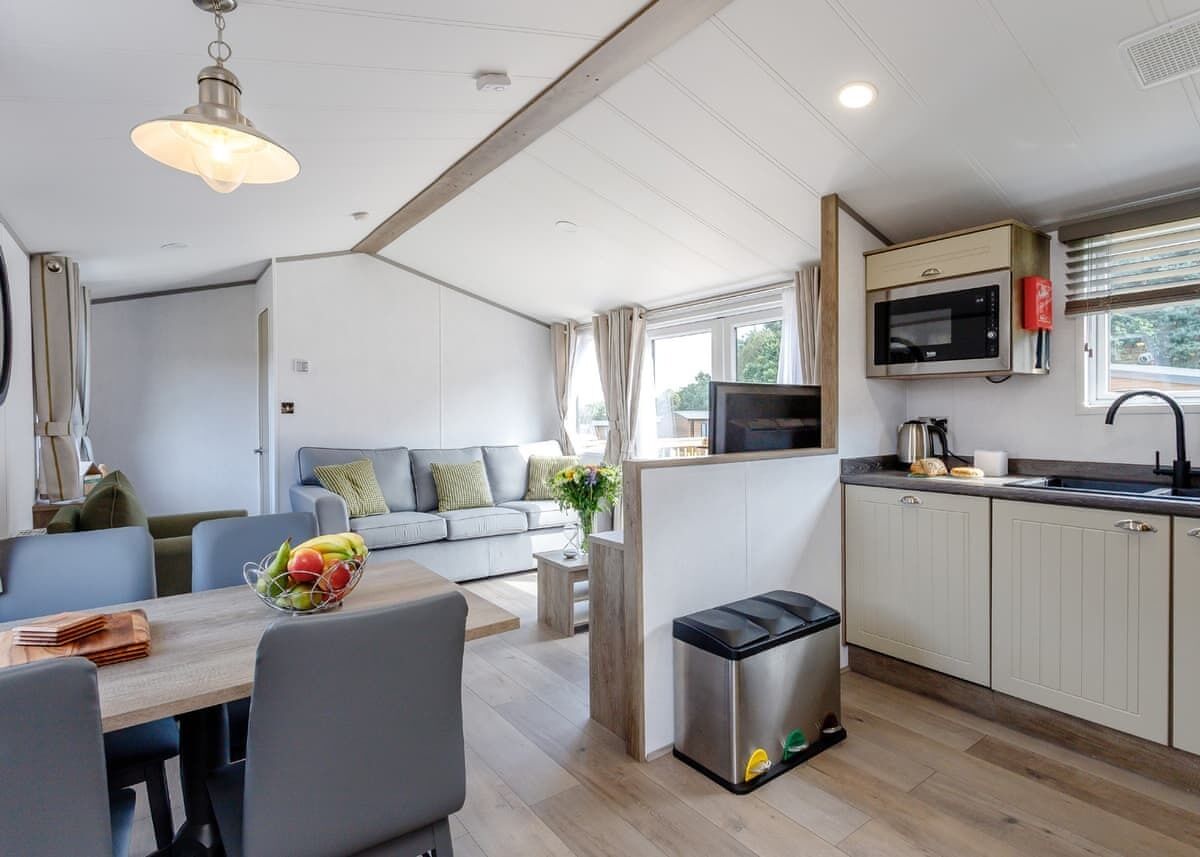 Un espace de vie compact comprenant une kitchenette, un coin repas et un canapé dans le salon.