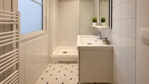 A modern bathroom with a shower, sink, and a window with a view. - 3 pieces pres du Pantheon (Paris)