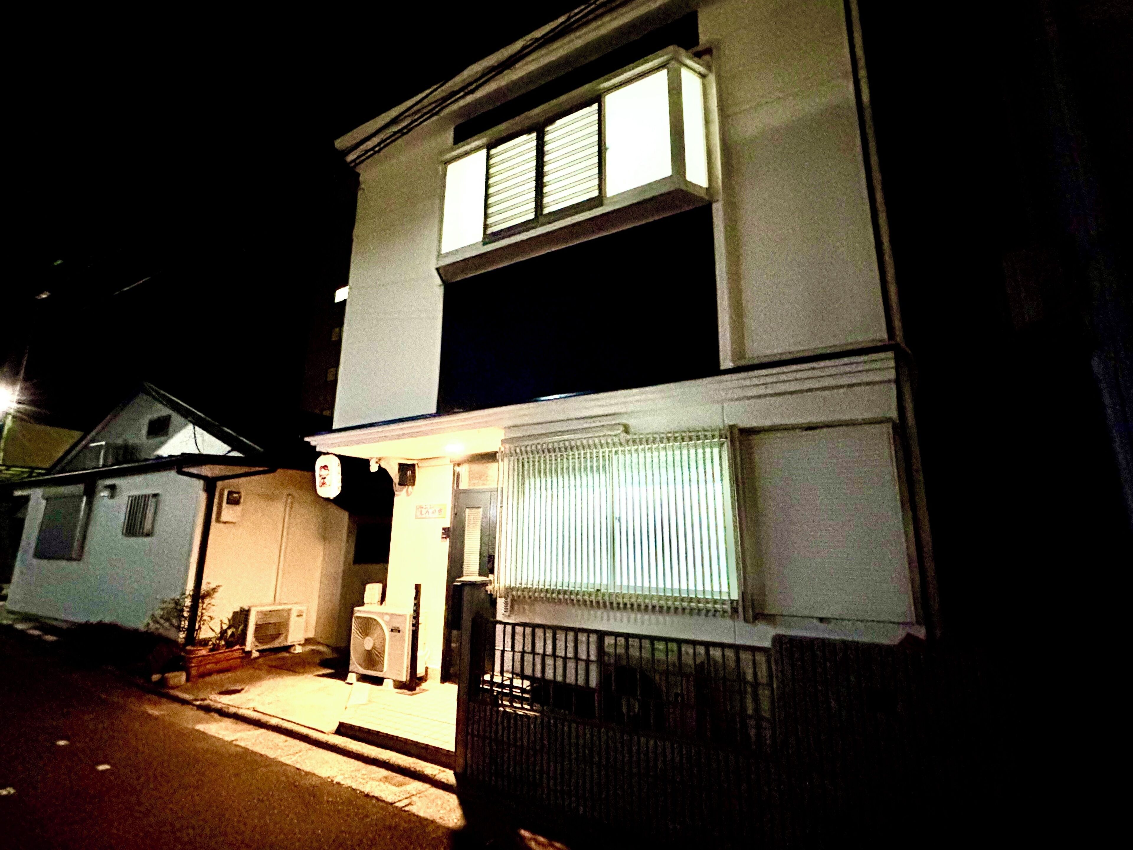 A two-story house with a balcony and a small porch area.
