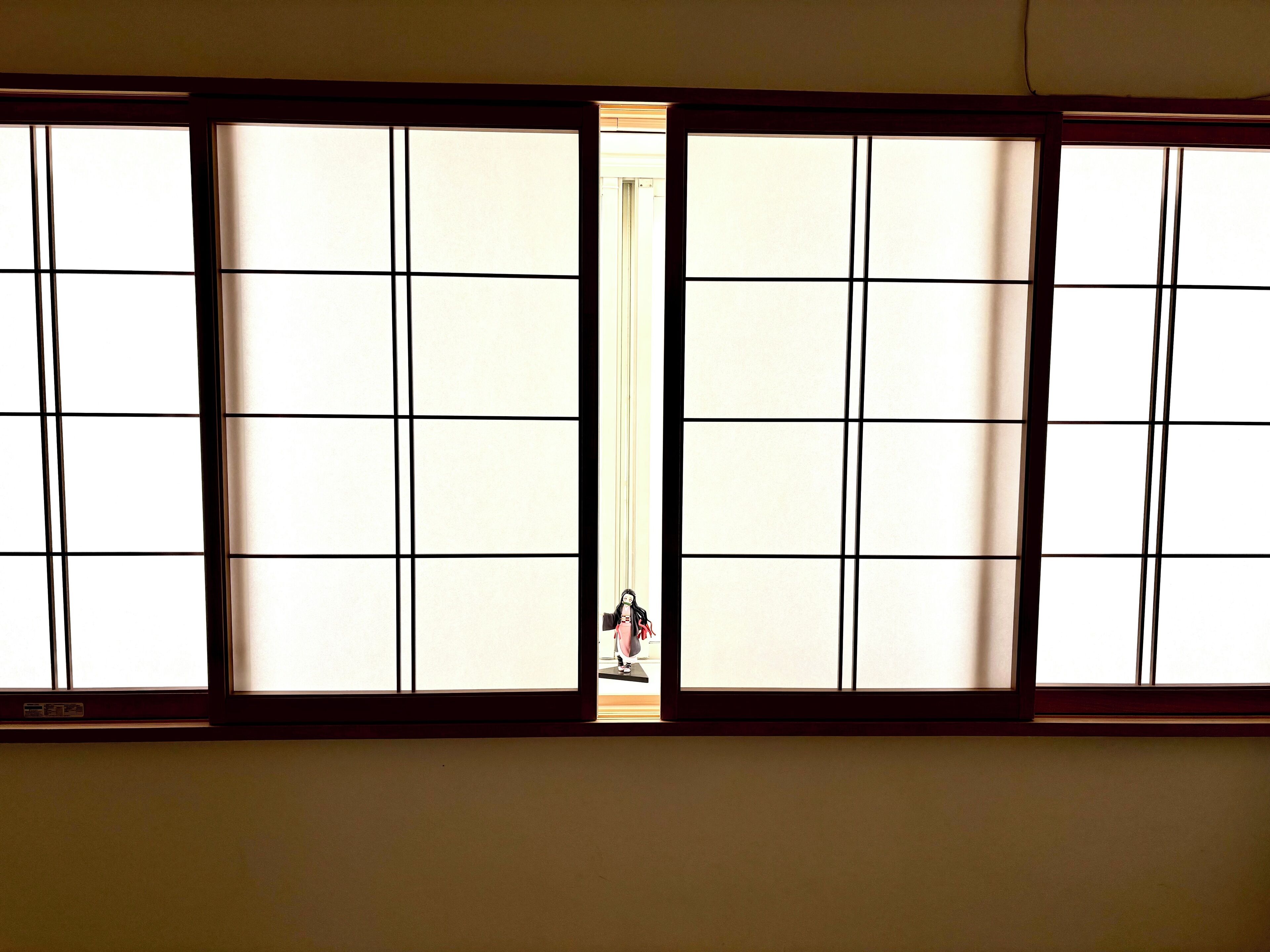Ein Zimmer mit einem großen Fenster, das ein Gittermuster aufweist.