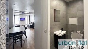 Un intérieur moderne comprenant un coin repas, un salon et une salle de bain.
