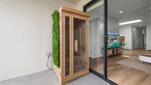 A modern room with a wooden cabinet, a green wall, and a large window.