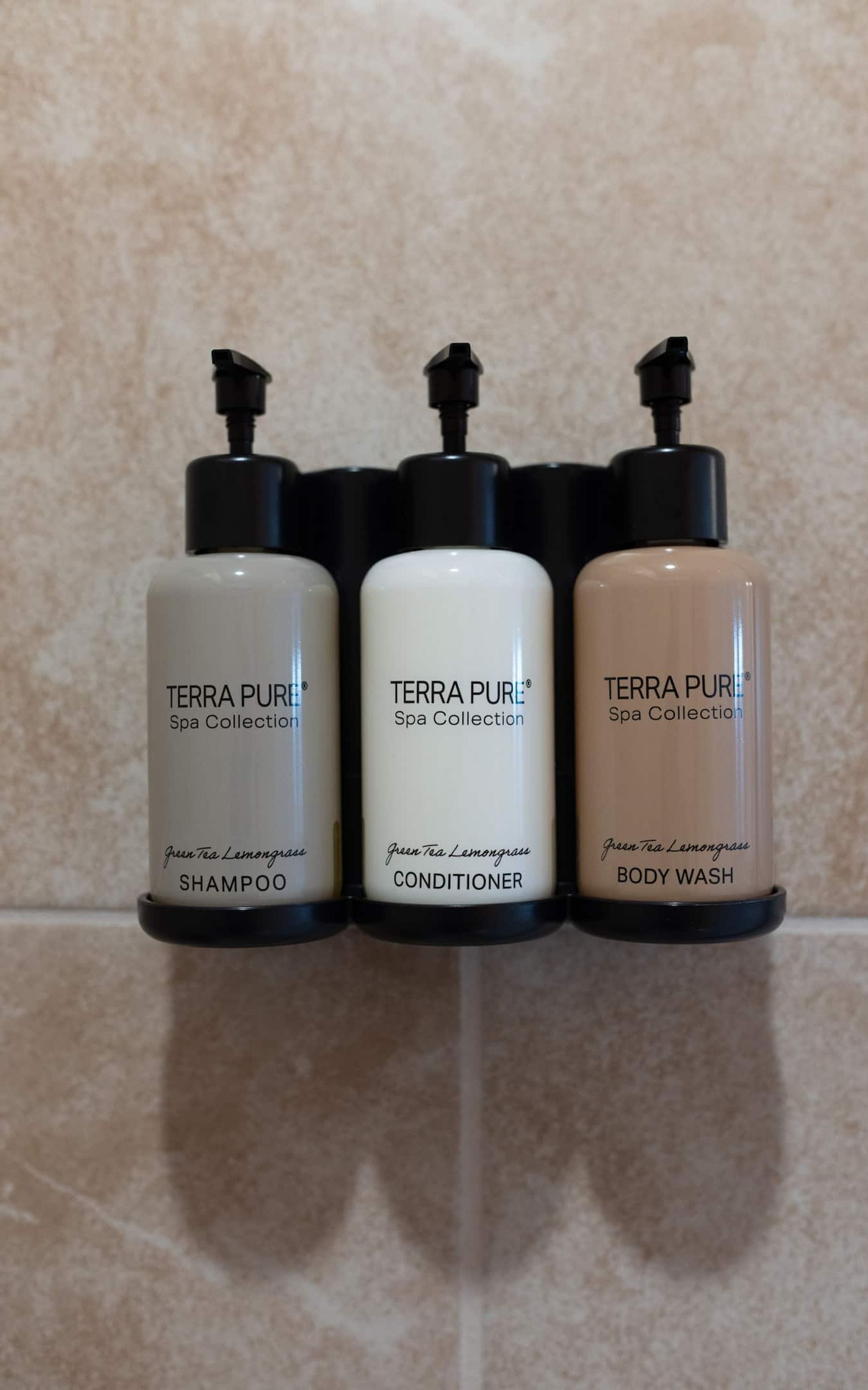 Three bottles of Terra Pure Spa Collection products: green tea lemongrass shampoo, conditioner, and body wash.