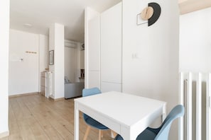 A modern kitchen with white cabinets, a white countertop, and a built-in oven.