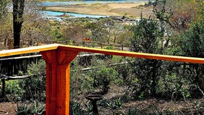 A patio with a view of a river and distant hills.
