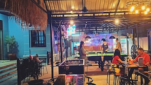 An indoor bar with pool tables, seating areas, and a bar counter. - Angkor Gecko's Inn (Siem Reap)