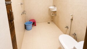 A small bathroom with a toilet, a sink, and a shower. - Hotel Marwari (Agra)