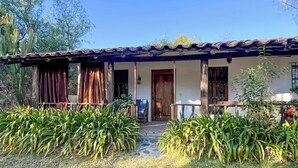 A rustic house with a tiled roof, a wooden porch, and a stone pathway leading to the entrance. - w Peaceful 1BR Surrounded by Nature in Huaraz (Yungar)