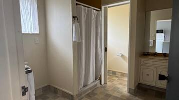 Un baño con ducha, inodoro y lavabo con espejo.