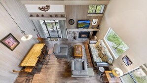 A spacious living area with a fireplace, a long wooden table, and comfortable seating.