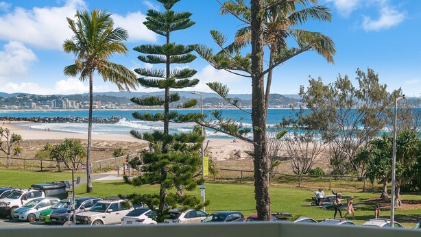 Vista costera con zona de estacionamiento, playa y océano.