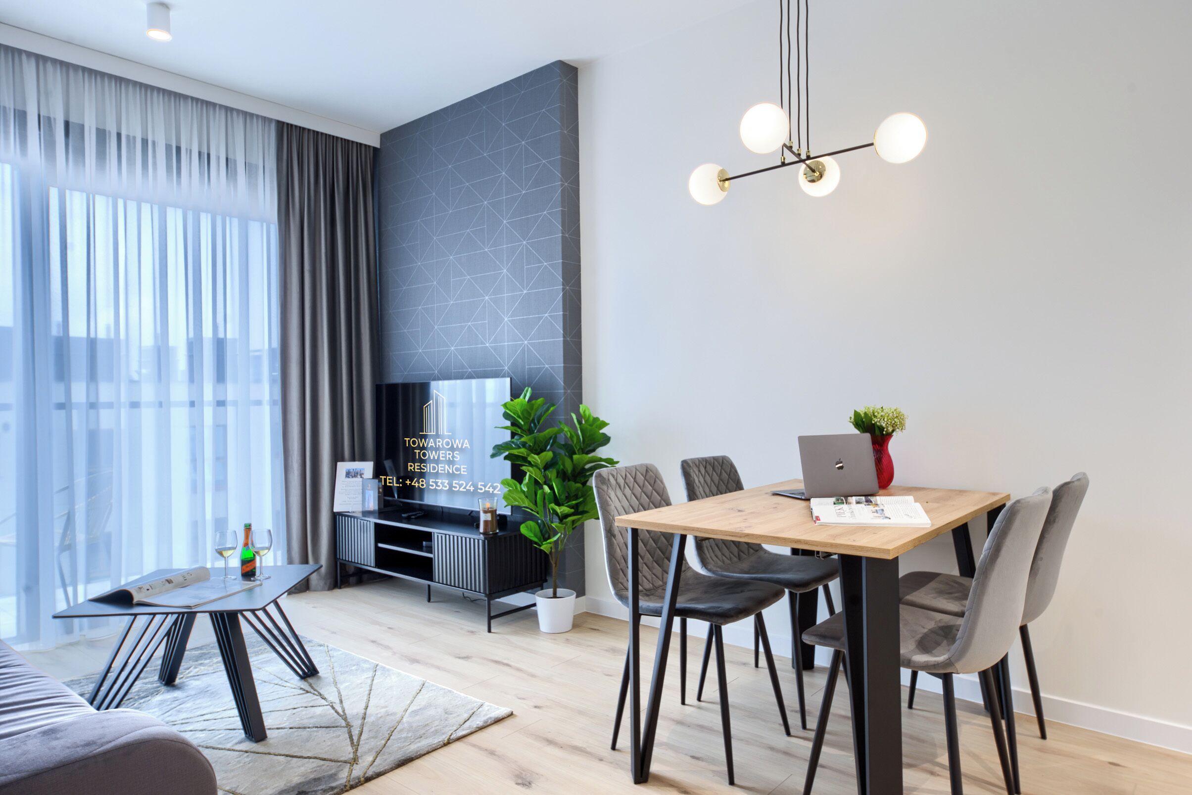 Una sala de estar moderna con comedor, televisor y planta.