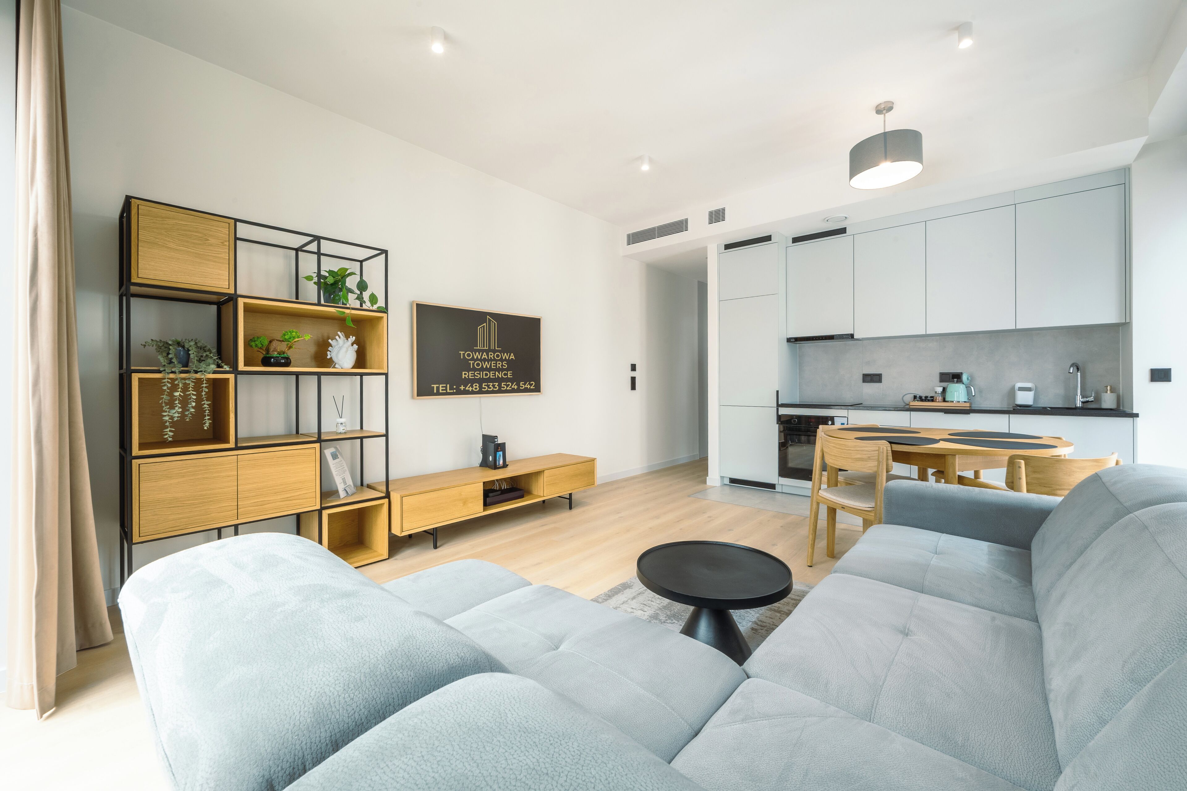 Ein modernes Wohnzimmer mit einer Couch, einem Couchtisch und einer eingebauten Bücherwand.