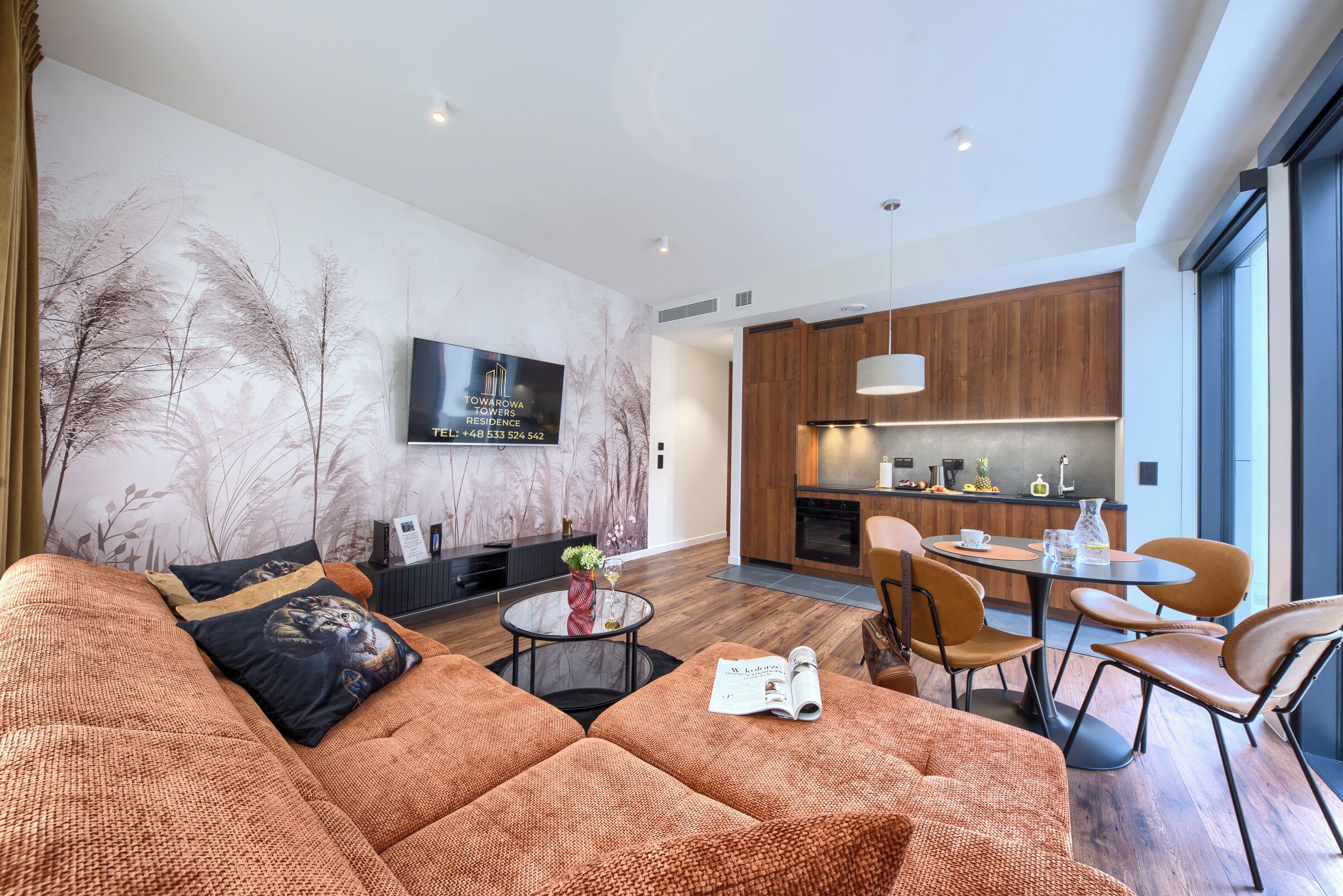 A modern living room with a sofa, a coffee table, and a dining area with chairs.