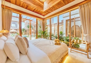 A spacious bedroom with a large bed, wooden ceiling, and a view of a pool and greenery. - Villa Lima 8BDR Jacuzzi, Sauna, Ice-bath, Cinema (Kecamatan Kuta)