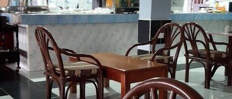 A restaurant with a counter, chairs, and a tiled floor.