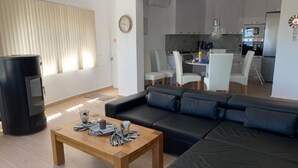 A modern living room with a black sofa, wooden coffee table, and a TV stand. - Villa Emilia 4 Personas (Calpe)