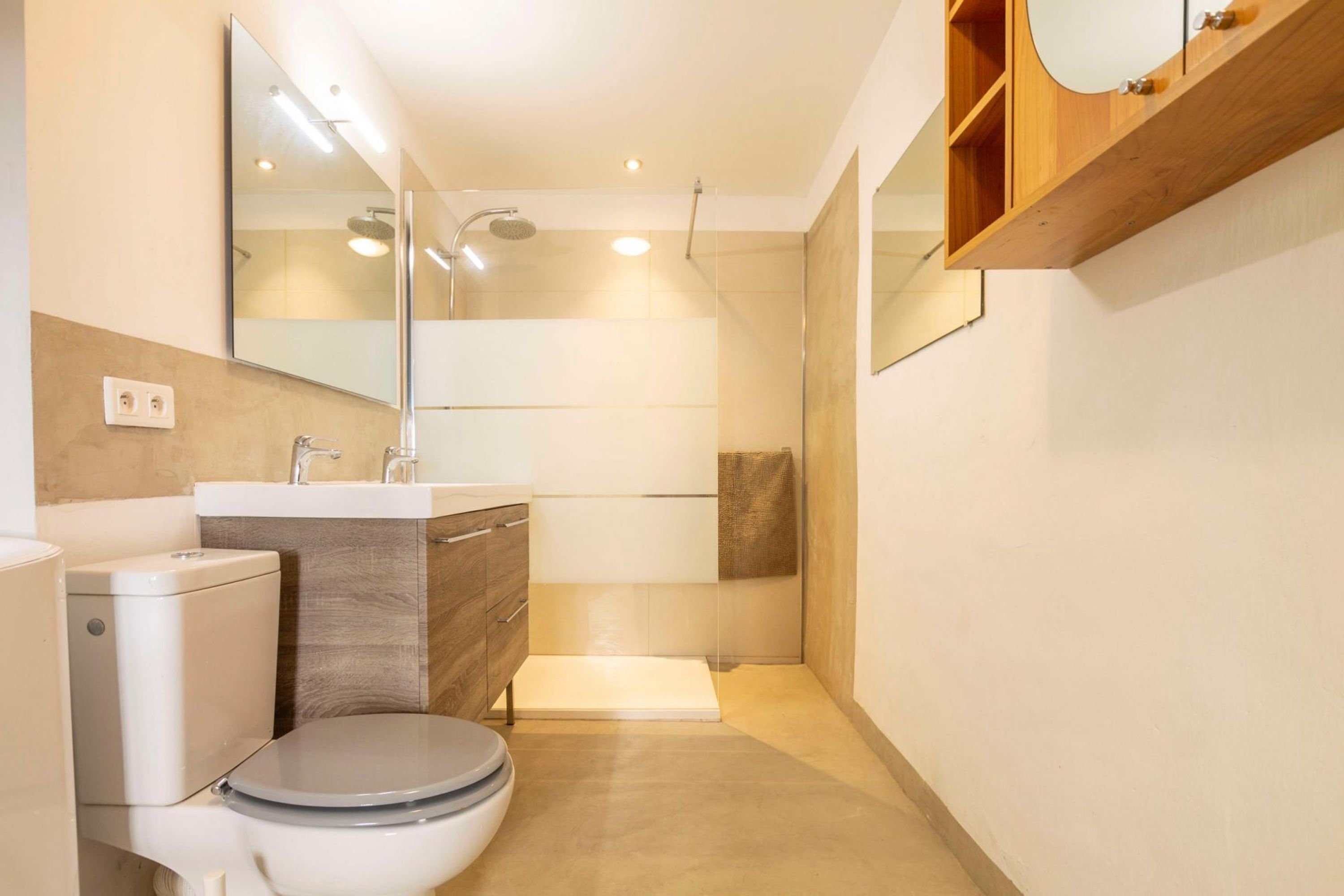 A modern bathroom with a toilet, sink, and shower area.