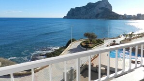 A balcony with a view of the sea, a rocky outcrop, and a cityscape in the distance. - Apartamento Mar Timo 4 Personas (Calpe)