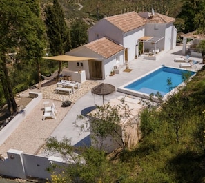 A modern villa with a swimming pool, outdoor seating, and a scenic hillside view. - Vista Las Colinas in Izn jar (Iznajar)