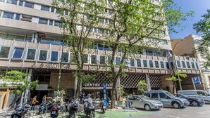 A multi-story building with a parking area and several parked motorcycles. - Colon 902 in Madrid With 1 Bedrooms and 1 Bathrooms (Madrid)