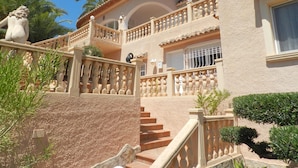 A multi-story building with a central courtyard, a staircase, and a statue. - Villa Ambiente Para 4 Personas (Calpe)